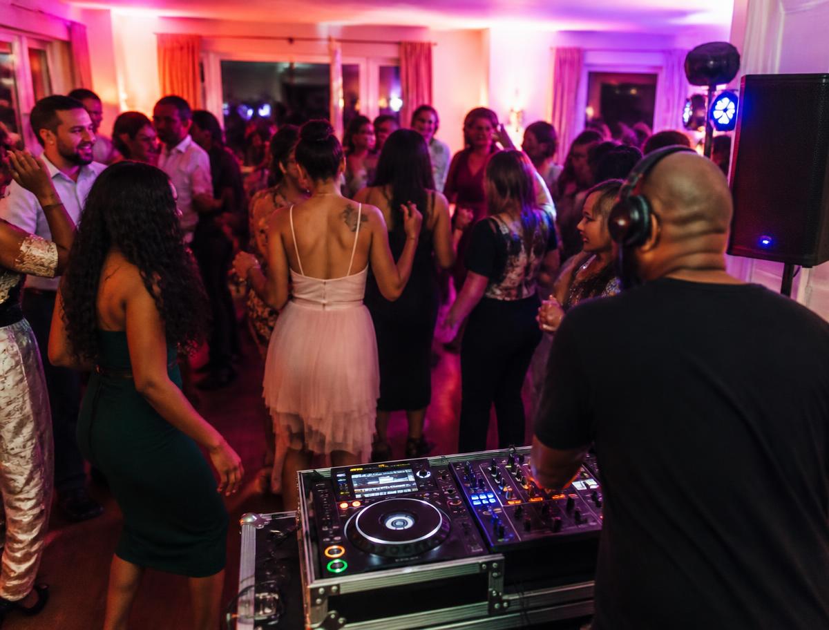 DJ performing at a private party with guests dancing